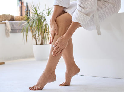 woman applying cream to her legs