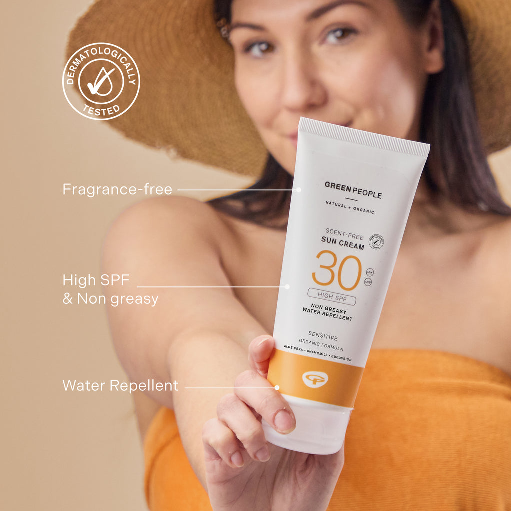 A woman in a sun hat holds a tube of Scent Free Sun Cream SPF30 200ml with text pointing out its fragrance-free, organic formula.